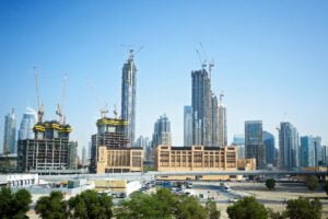 Dubai City with construction cranes working at daylight